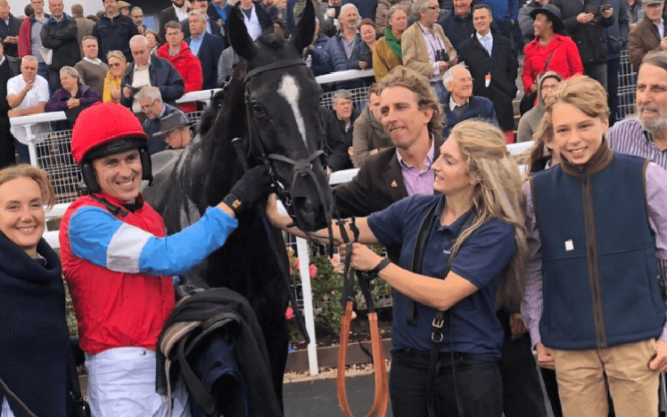 A winning team celebrate with their racehorse